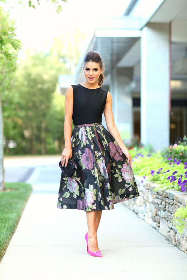 We see a black sleeveless top tucked in high-rise midi flared skirt printed  in gorgeous florals. Complete the look by adding blush fuchsia glossy