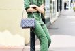 An army green jumpsuit is worn with a chain shoulder bag, white pumps, and  mirrored sunglasses