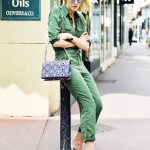 An army green jumpsuit is worn with a chain shoulder bag, white pumps, and  mirrored sunglasses