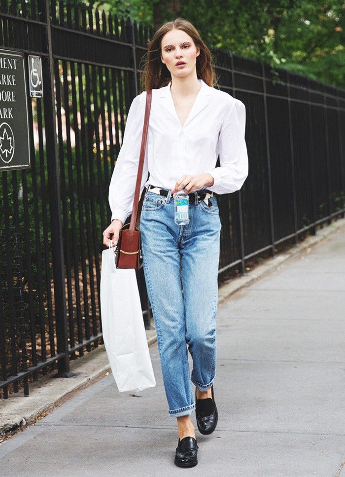 Model Tilda Lindstam in a simple white button-down, loose jeans and loafers