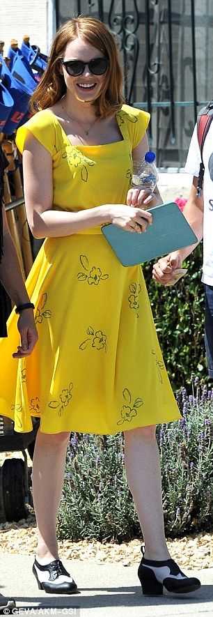 Emma Stone glows in a canary yellow dress while on set of La La Land